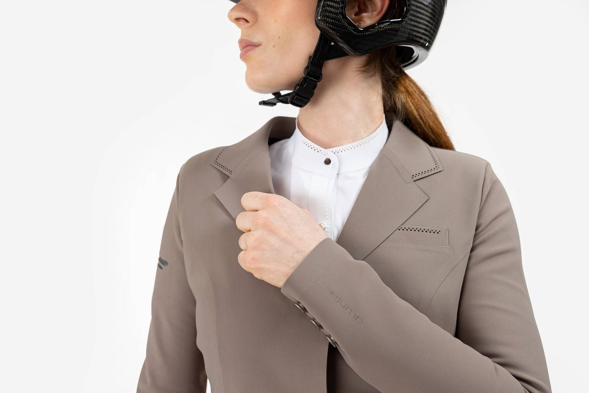 Close up of beige Freejump Women's Show coat to show "freejump" on left sleeve and Laser-cut perforated bands on the bottom of the pockets and on the collar