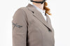 Close up of beige Freejump Women's Show Jacket to show dragonfly emblem on right shoulder and Laser-cut perforated bands on collar