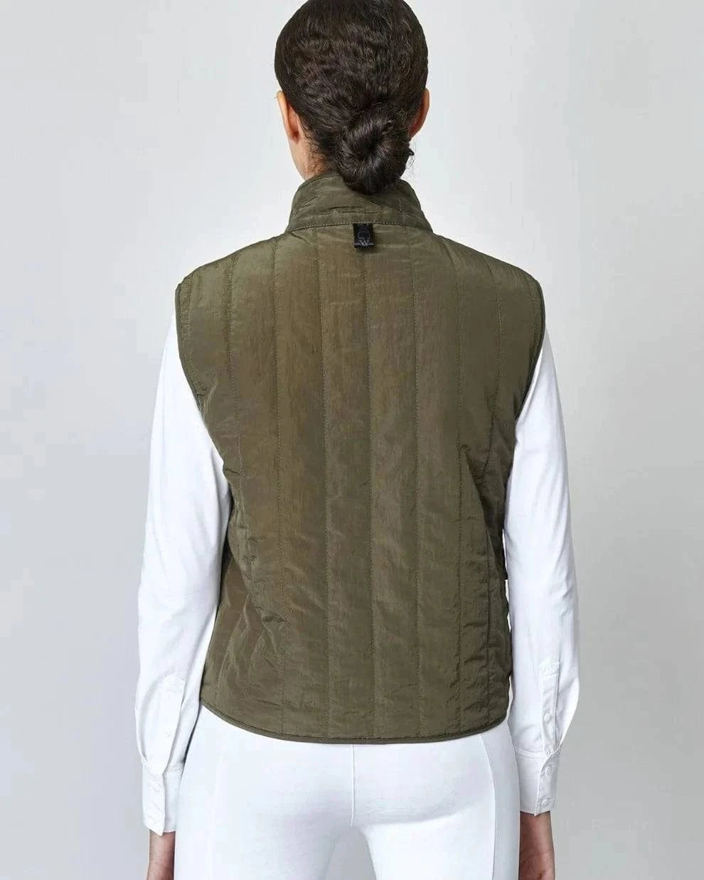 The Green Quilted Riding Vest offers a boxy silhouette with a stand-up collar, front zipper, and placket with easy press studs. The exterior is both wind-proof and water-repellent while Primaloft Padding insulates to provide optimal warmth throughout your ride. Feature two front pockets, two invisible side seam pockets, and an inner pocket. Cut from an Italian fabric, and sewn in Europe.