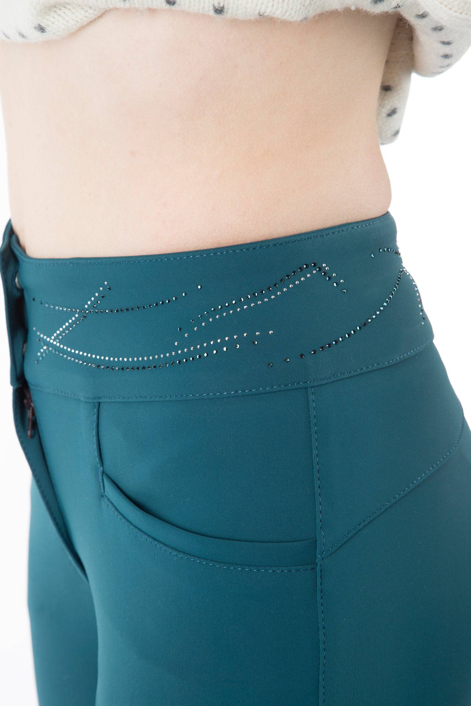 Deep Teal Women's high-waist breeches with knee grip. The waist has a two-button closure. Black ankle cuffs. Animo logo on outer thigh and design on waistband – both in rhinestones.