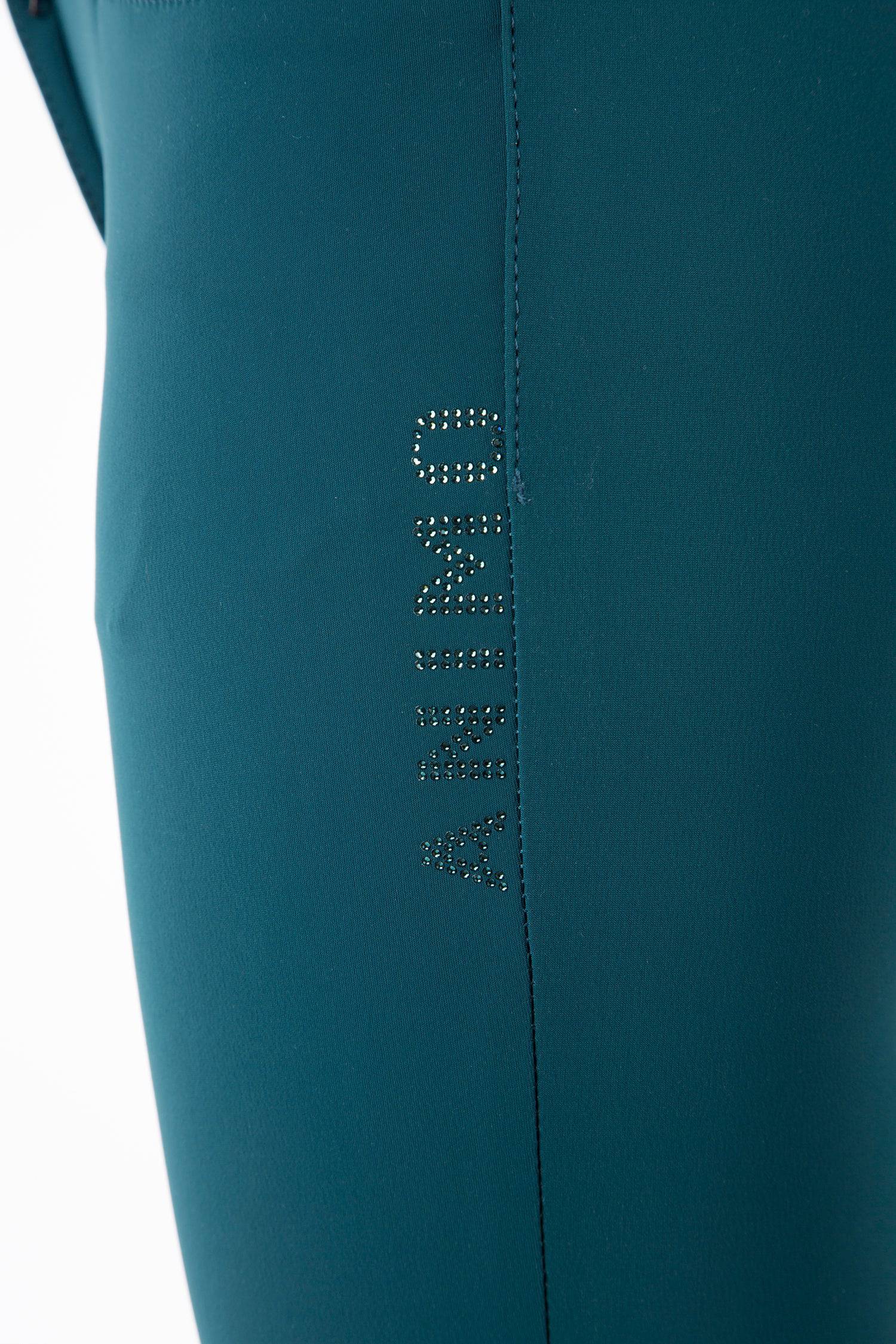 Deep Teal Women's high-waist breeches with knee grip. The waist has a two-button closure. Black ankle cuffs. Animo logo on outer thigh and design on waistband – both in rhinestones.